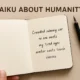 Handwritten haiku about humanity in a notebook, expressing human emotion through simple poetry