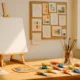 Bright artist workspace with a blank canvas on an easel, jars of brushes, and colorful paint tubes scattered on a wooden desk in warm natural light.